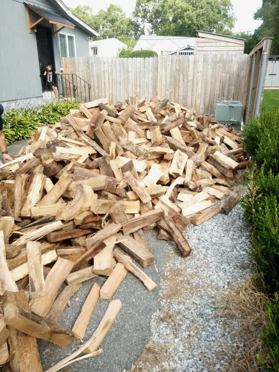 Seasoned firewood delivered beside a home in a Northern Rhode Island driveway