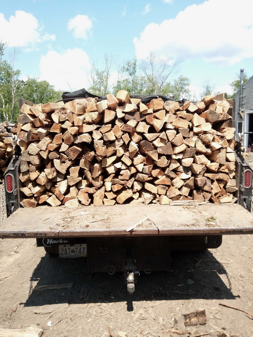 Cote Landscape dump truck loaded with neatly stacked split hardwood firewood for delivery in Northern Rhode Island